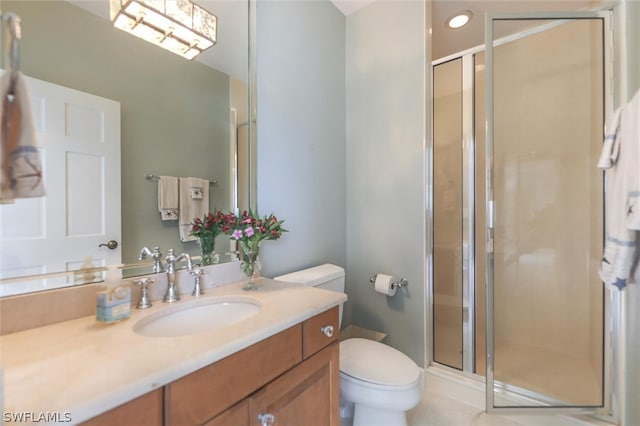 bathroom with tile patterned flooring, a shower with door, vanity, and toilet