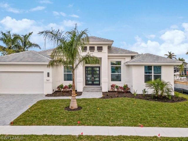 view of front of home featuring french doors, a front lawn, and a garage