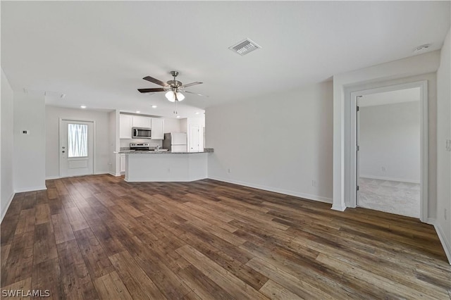 unfurnished living room featuring ceiling fan and dark wood-type flooring