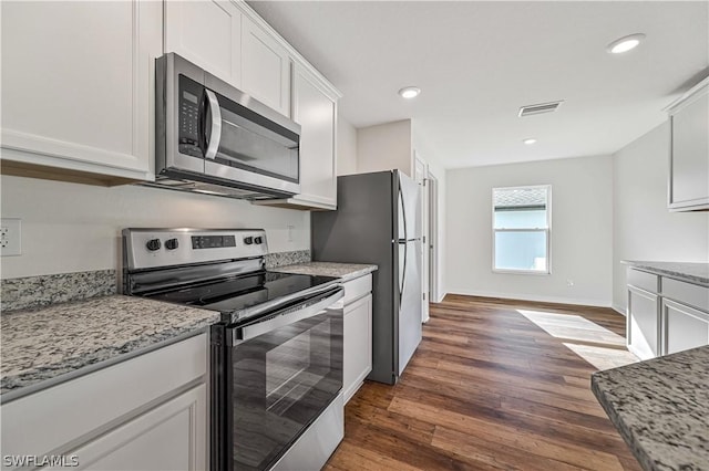 kitchen featuring white cabinetry, dark hardwood / wood-style flooring, light stone counters, and appliances with stainless steel finishes