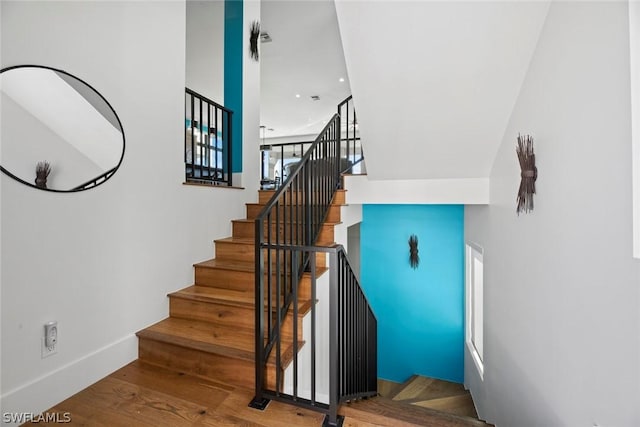 staircase with hardwood / wood-style floors