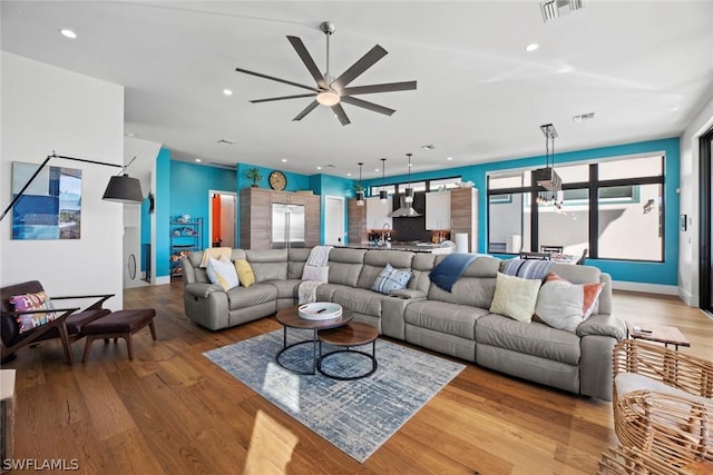 living room with ceiling fan and light hardwood / wood-style flooring