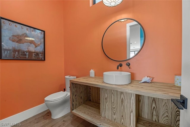 bathroom featuring sink, hardwood / wood-style floors, and toilet