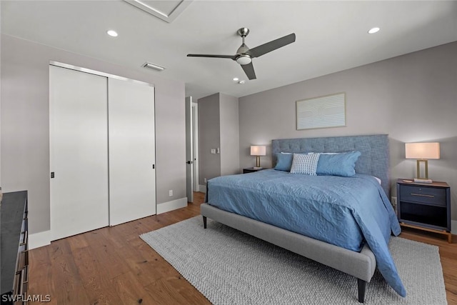 bedroom with hardwood / wood-style floors, ceiling fan, and a closet