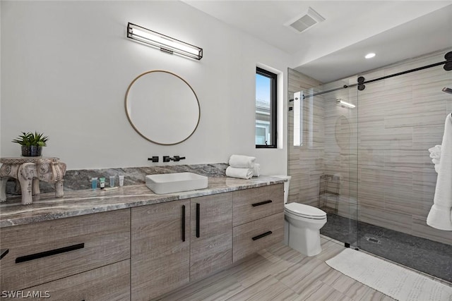 bathroom featuring vanity, toilet, and an enclosed shower