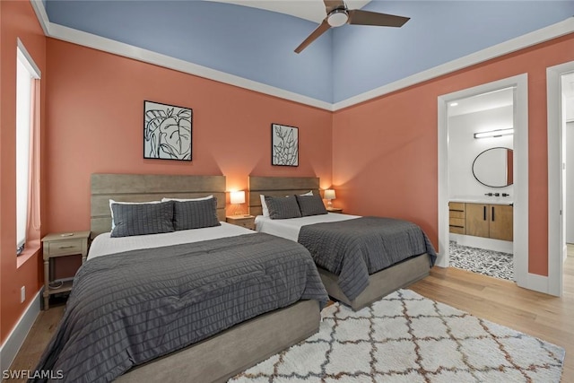 bedroom with ensuite bathroom, sink, ceiling fan, and light hardwood / wood-style flooring
