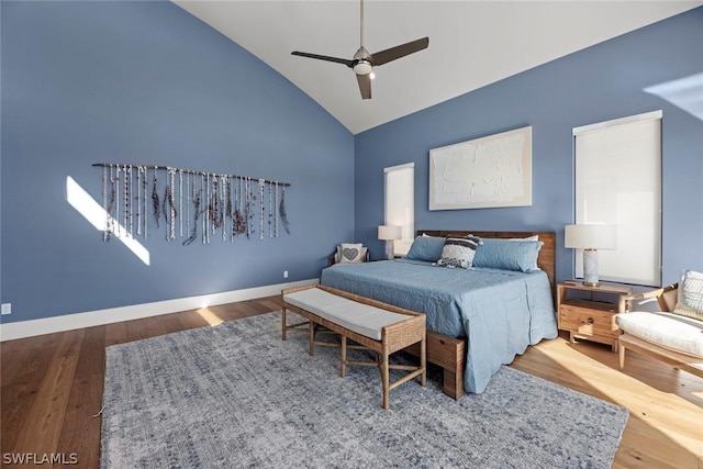 bedroom with hardwood / wood-style flooring, high vaulted ceiling, and ceiling fan