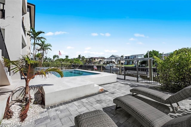 view of swimming pool featuring a water view and a patio area