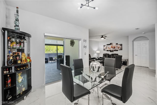 dining room with light tile floors and ceiling fan with notable chandelier