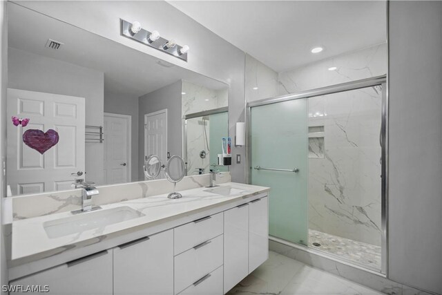 bathroom with tile flooring, vanity with extensive cabinet space, an enclosed shower, and double sink