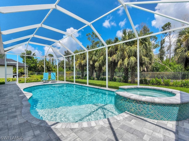 view of pool with an in ground hot tub, a patio, glass enclosure, and a lawn