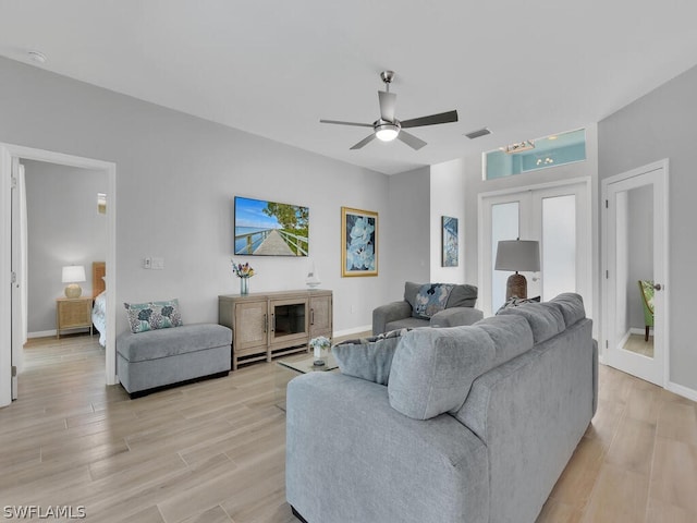 living room with ceiling fan, light wood-type flooring, and french doors