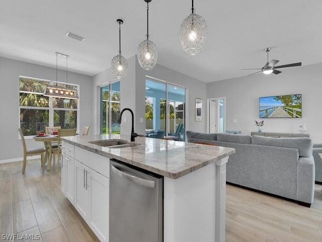 kitchen featuring pendant lighting, a center island with sink, stainless steel dishwasher, light stone counters, and white cabinetry