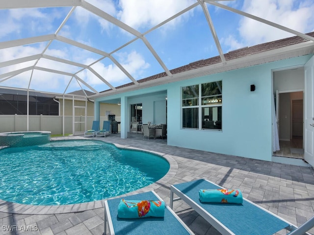 view of swimming pool with a patio area, an in ground hot tub, and glass enclosure