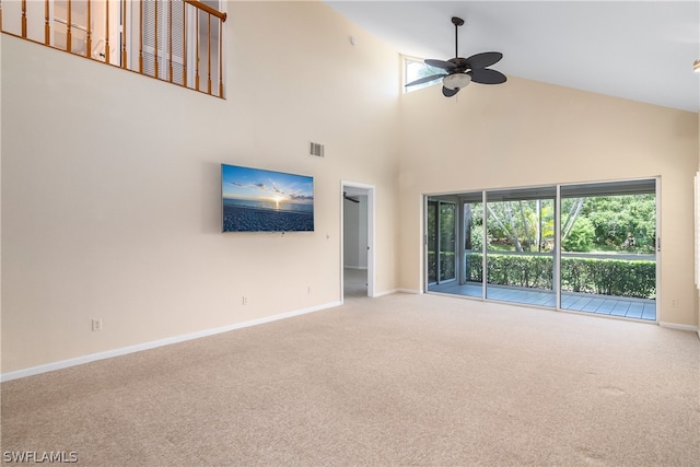 unfurnished living room featuring carpet flooring, ceiling fan, and a high ceiling