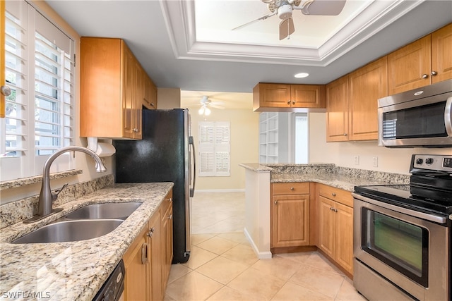 kitchen with light stone countertops, sink, stainless steel appliances, a raised ceiling, and light tile patterned floors