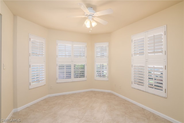 spare room featuring ceiling fan and light tile patterned flooring