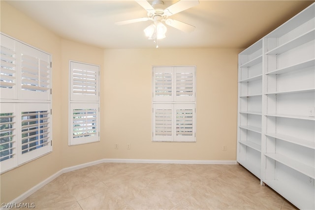 empty room with ceiling fan and light tile patterned flooring