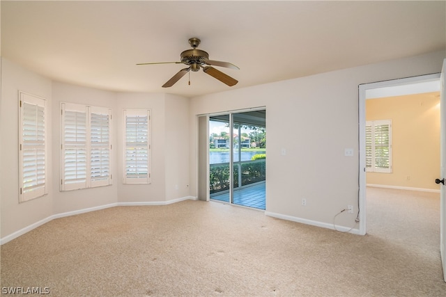 empty room featuring ceiling fan and light colored carpet