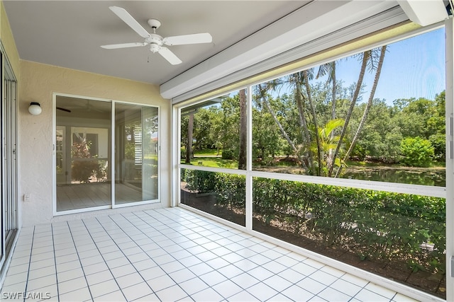 unfurnished sunroom with a water view and ceiling fan