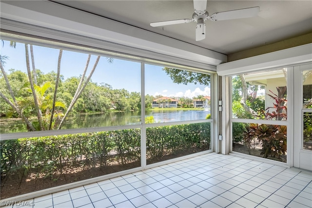 unfurnished sunroom featuring a water view and ceiling fan