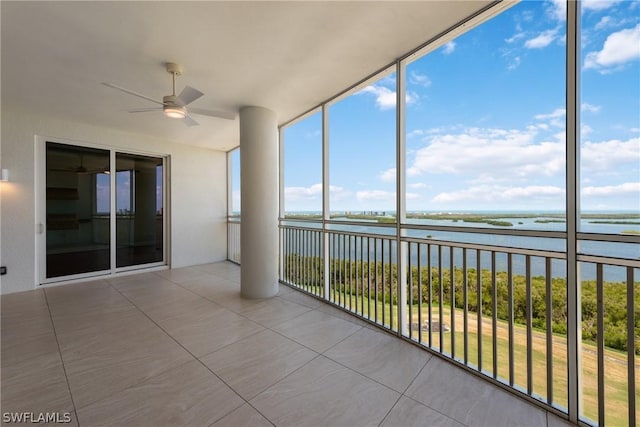 unfurnished sunroom with a water view and ceiling fan