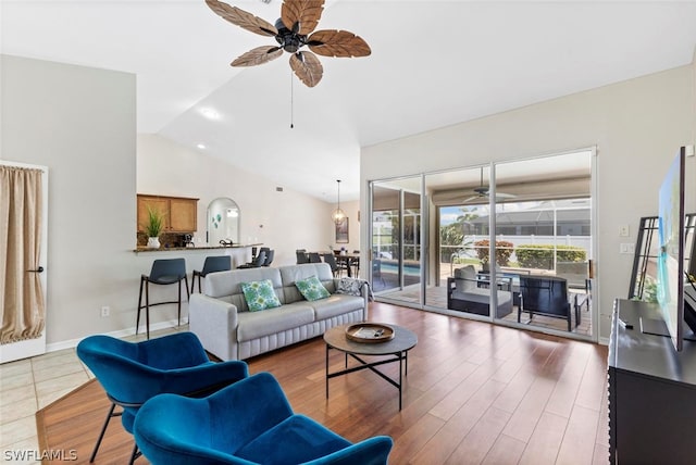 living room with high vaulted ceiling, dark tile flooring, and ceiling fan