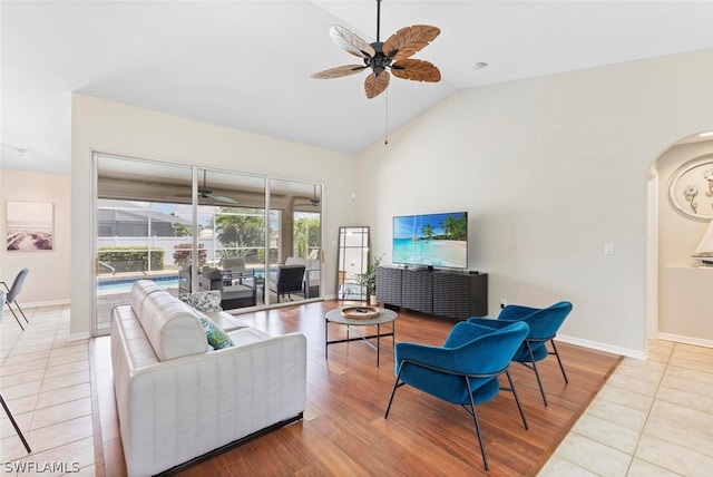 tiled living room featuring high vaulted ceiling and ceiling fan