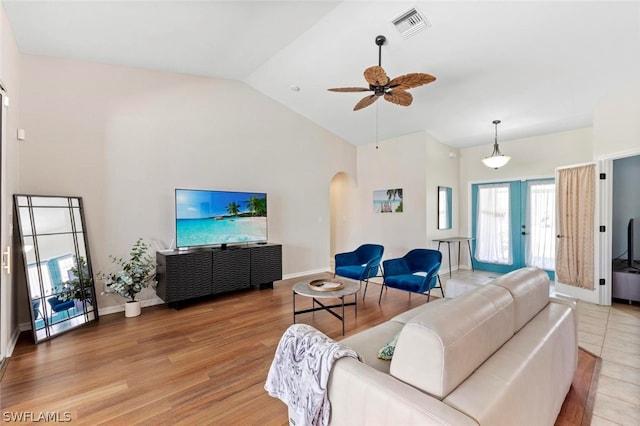 living room featuring high vaulted ceiling, ceiling fan, and light wood-type flooring