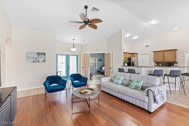 living room with vaulted ceiling, ceiling fan, and light hardwood / wood-style flooring