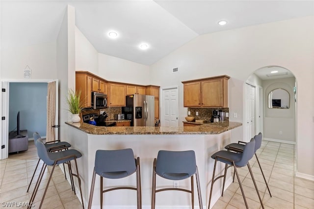 kitchen featuring appliances with stainless steel finishes, tasteful backsplash, and light tile flooring