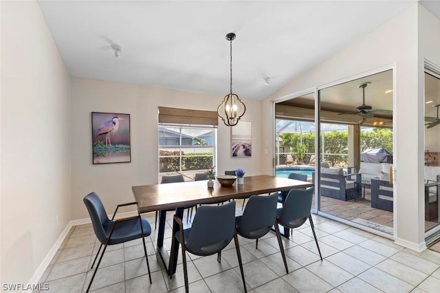 tiled dining room featuring ceiling fan with notable chandelier and vaulted ceiling