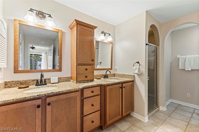 bathroom with tile floors, dual sinks, a shower with door, and large vanity