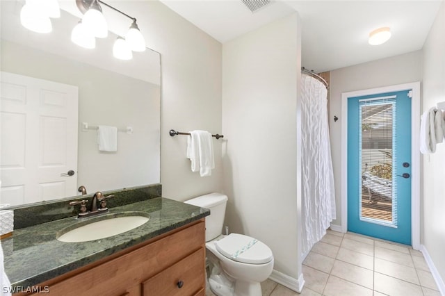 bathroom featuring tile flooring, toilet, and vanity