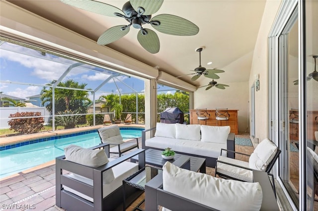 exterior space with an outdoor living space, grilling area, glass enclosure, ceiling fan, and a patio