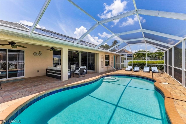 view of swimming pool with ceiling fan, a lanai, and a patio area