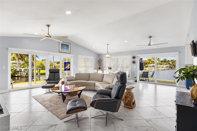 living room with ceiling fan with notable chandelier, a water view, and lofted ceiling