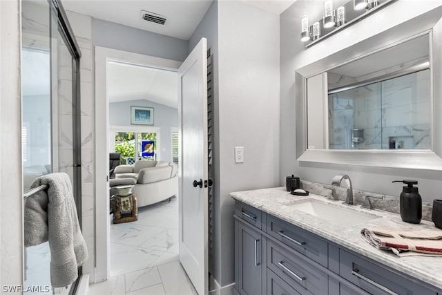 bathroom with vanity, a shower with shower door, and vaulted ceiling