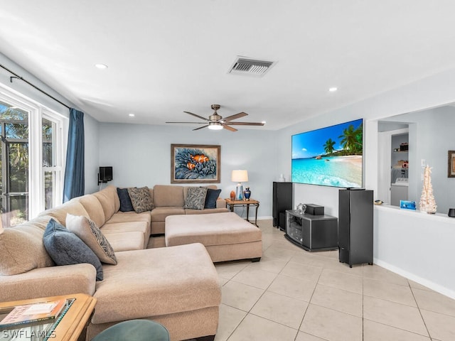 living room with washer / dryer, ceiling fan, and light tile patterned floors