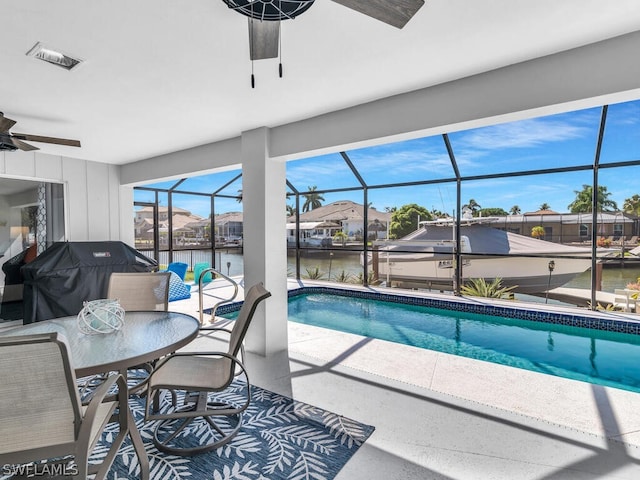 view of swimming pool featuring ceiling fan, grilling area, and a water view