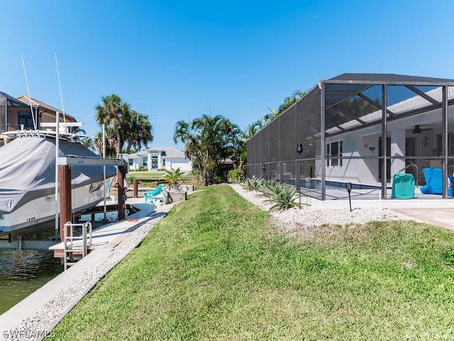 view of yard featuring glass enclosure, a pool, a water view, and a dock