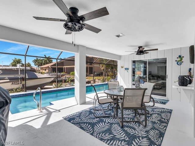 view of pool with ceiling fan, glass enclosure, and a patio area