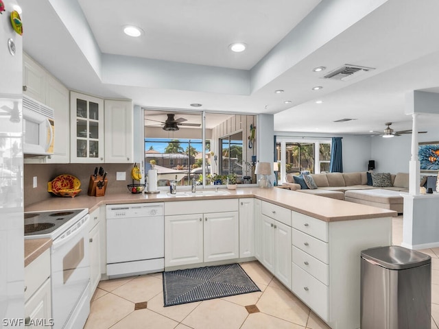 kitchen featuring kitchen peninsula, sink, white appliances, and white cabinetry