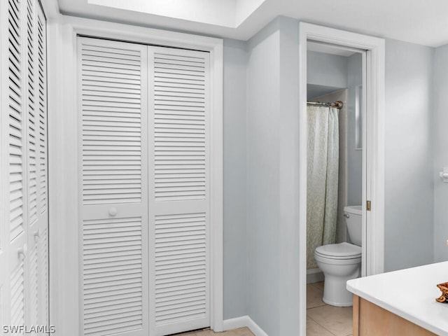 bathroom with toilet, vanity, a shower with curtain, and tile patterned floors