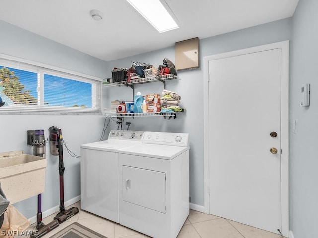 clothes washing area featuring light tile patterned flooring and washing machine and clothes dryer