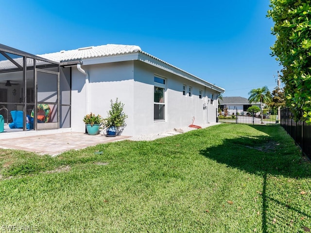 back of house with a lanai, a lawn, and a patio