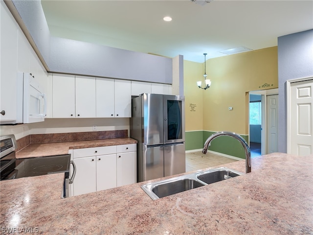 kitchen with stainless steel appliances, white cabinetry, sink, light tile patterned floors, and decorative light fixtures