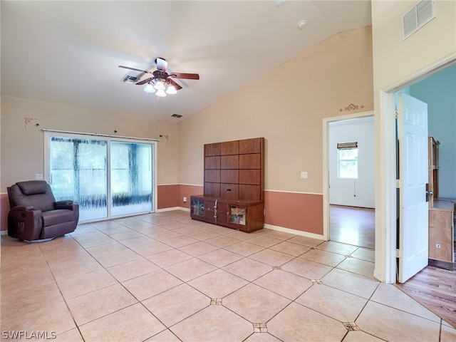 unfurnished living room featuring high vaulted ceiling, light tile patterned floors, and ceiling fan