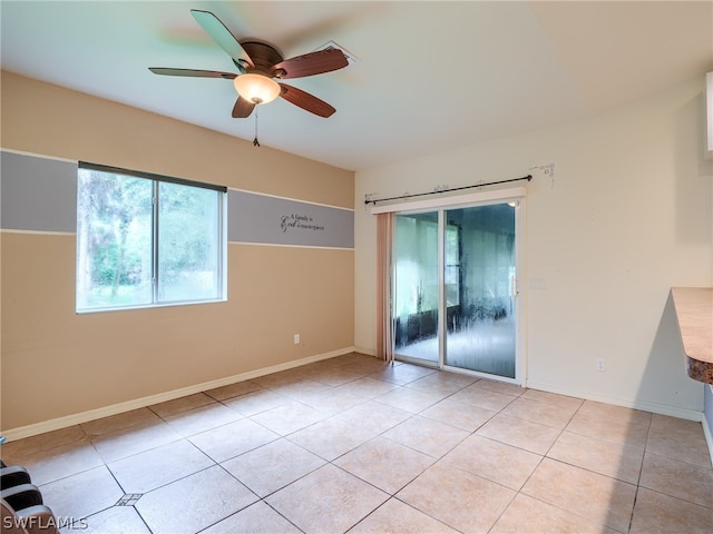 tiled spare room featuring ceiling fan