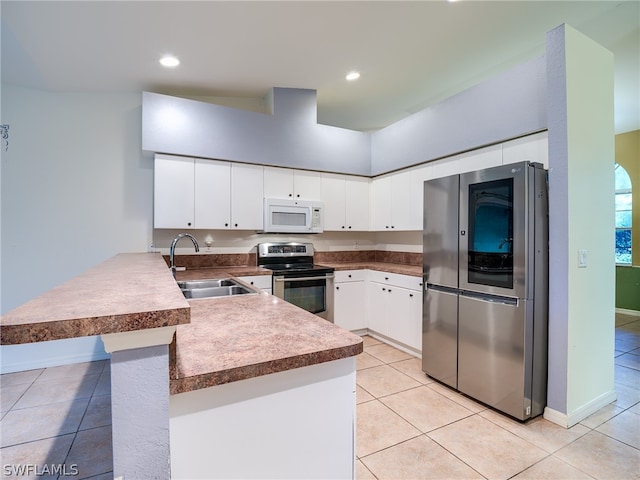 kitchen with stainless steel appliances, light tile patterned floors, sink, and kitchen peninsula